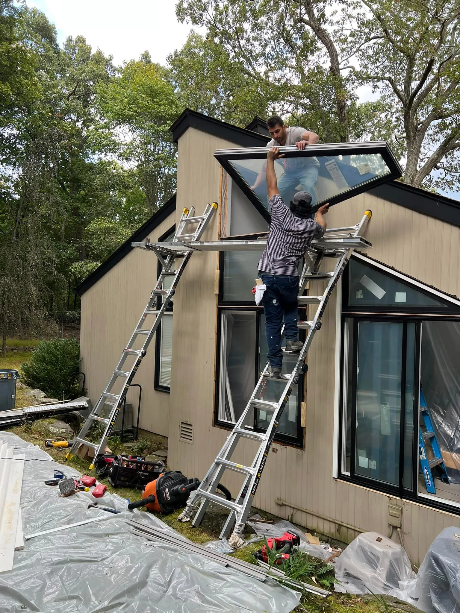 Custom triangular Andersen windonws being lifted into position.