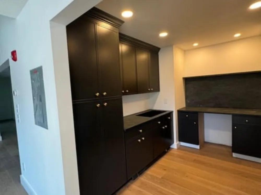 Custom Interior Renovation showcasing a modern kitchen with dark cabinetry and wood flooring.